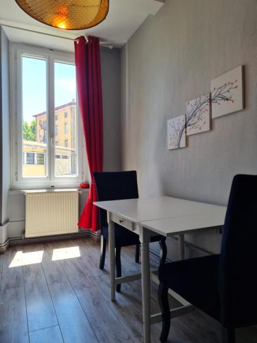 une salle à manger avec une table et des chaises et une fenêtre dans l'établissement La Belle Epoque, grand appartement en centre-ville, à Foix