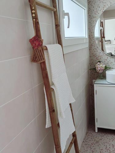 a towel ladder in a bathroom with a mirror at Casinha do Chico in Charneca
