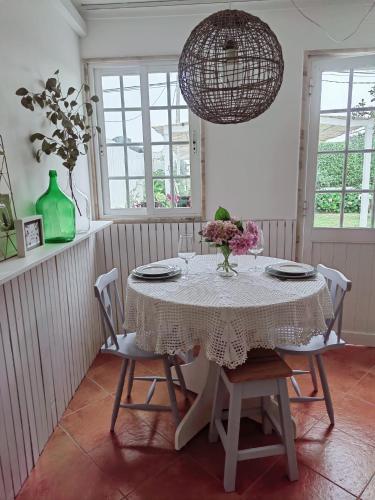 a dining room with a table with chairs and a chandelier at Casinha do Chico in Charneca