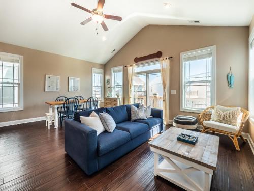 a living room with a blue couch and a table at Sundancer in Surf City