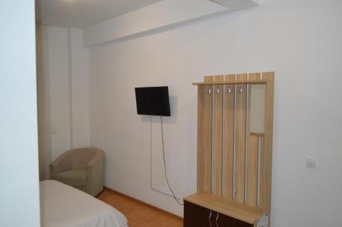 a bedroom with a bed and a tv on a wall at Pensiunea VisAventura in Vişan