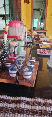 a counter with a bunch of dishes and a blender at Pousada Luar in Santana do Riacho