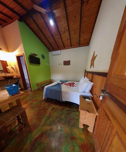 a bedroom with a bed in a room with green walls at Pousada Luar in Santana do Riacho