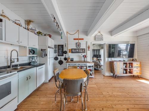 een keuken met witte kasten en een tafel met stoelen bij Vintage Vacation in Surf City