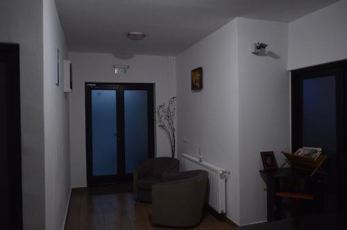 a living room with a chair and a door at Pensiunea VisAventura in Vişan