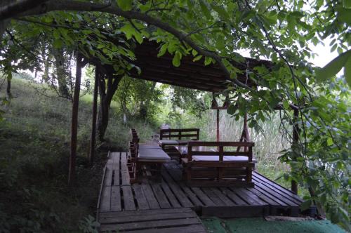 a wooden deck with a table and chairs under a tree at Pensiunea VisAventura in Vişan