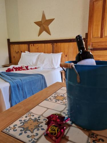 a room with a bed and a table with a bottle of wine at Pousada Luar in Santana do Riacho