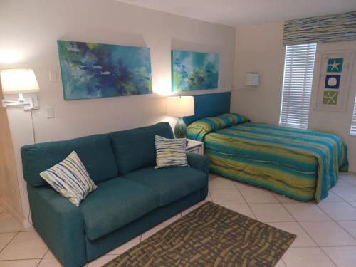 Islander Beach Resort - New Smyrna Beach في نيو سميرنا بيتش: غرفة معيشة مع أريكة وسرير