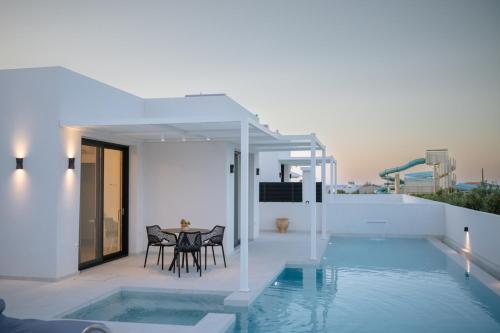 a villa with a swimming pool and a house at Sardines Luxury Suites in Hersonissos