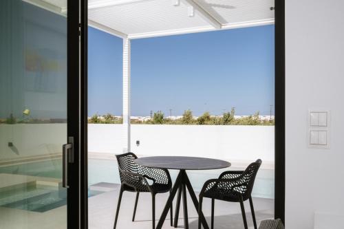 a table and chairs on a balcony with a view at Sardines Luxury Suites in Hersonissos