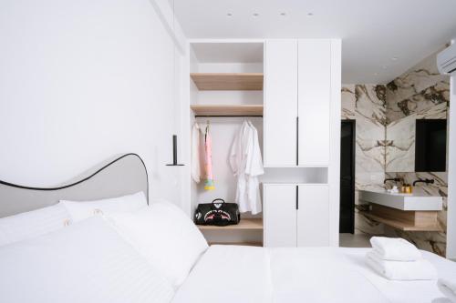 a bedroom with a white bed and a television at Sardines Luxury Suites in Hersonissos