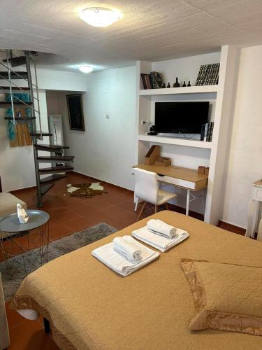 a room with a bed and a table with towels on it at Harmony Platanidia Pelion in Platanidia