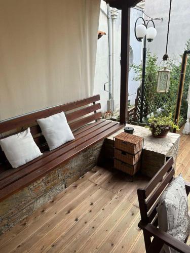 a wooden bench with two pillows on a patio at Harmony Platanidia Pelion in Platanidia