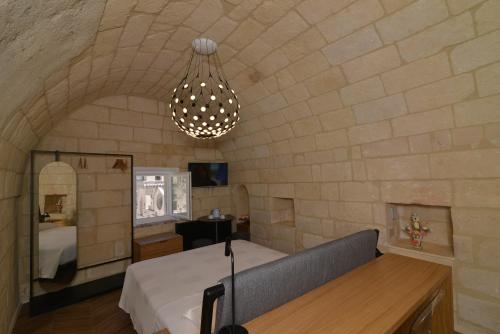 a bedroom with a bed and a chandelier at La Corte Dei Pastori in Matera