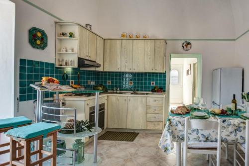 una cucina con armadi in legno, tavolo e sedie di Domus Smeraldo terrace and sea view Amalfi Coast a Massa Lubrense