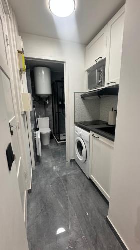 une petite cuisine avec un lave-linge et un sèche-linge. dans l'établissement Studio Cosy, à Paris