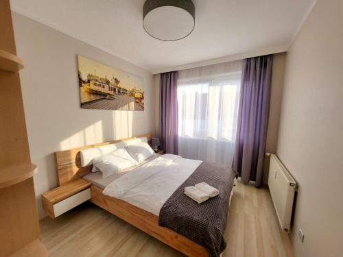 a bedroom with a bed and a large window at Apartament Margaretville 90m in Kołobrzeg