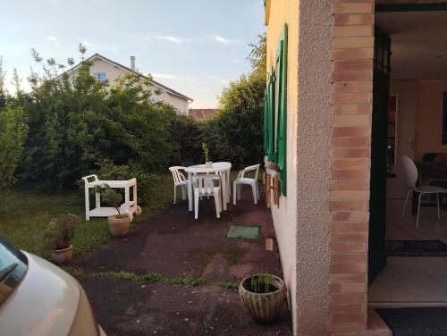 a patio with a table and chairs in a yard at l'Escale Thermale in Montrond-les-Bains