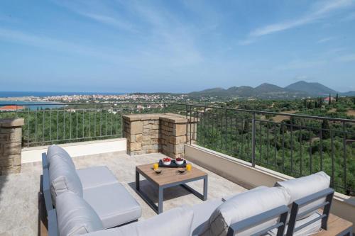 a living room with a couch and a table on a balcony at Modone Villas in Peloponnese in Methoni