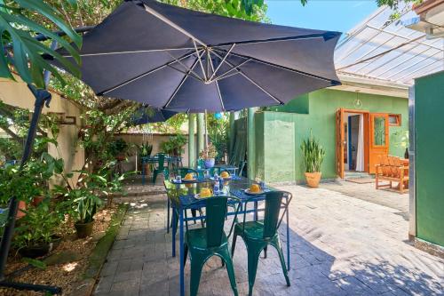 帕拉蒂的住宿－蓬塔爾花園旅館，露台上的桌子和遮阳伞