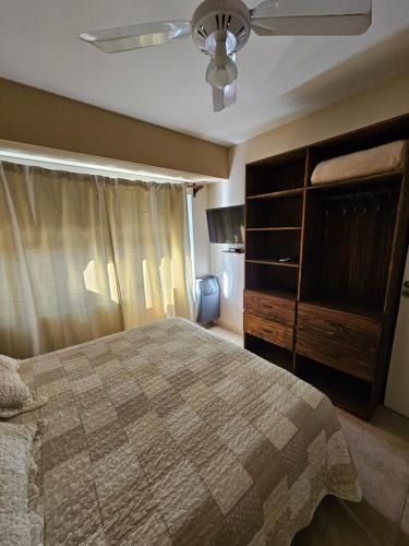 a bedroom with a bed and a ceiling fan at Resolana in Valeria del Mar
