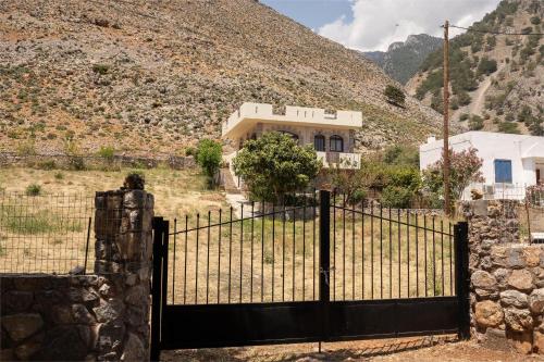 a gate in front of a house with a mountain at Artemisa House in Agia Roumeli