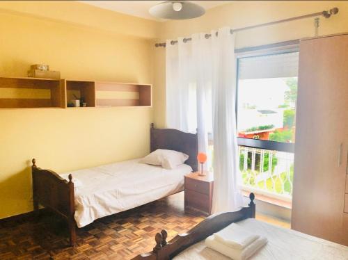 a bedroom with a bed and a large window at Cantinho da Glória in Aveiro