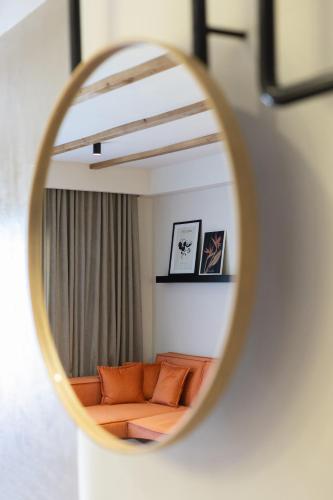 a mirror reflecting a couch in a living room at Kave luxurystaying in Volos