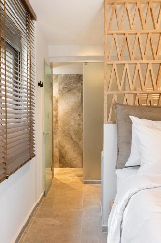 a bedroom with a white bed and a glass door at Kave luxurystaying in Volos