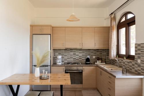 a kitchen with wooden cabinets and a wooden table at Artemisa House in Agia Roumeli