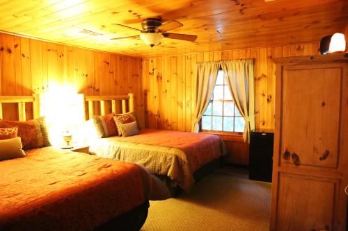 a bedroom with two beds and a ceiling fan at Grandview Lodge in Waynesville