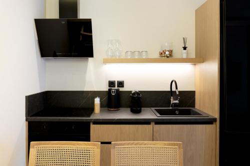 a kitchen with a sink and a counter with two chairs at Kave luxurystaying in Volos