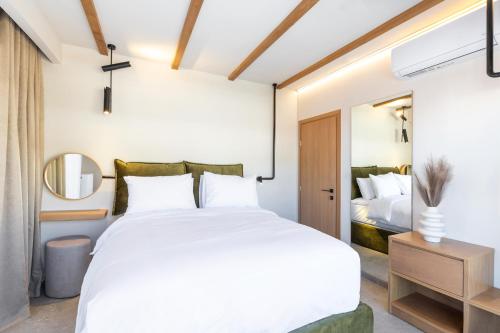 a bedroom with a large white bed and a mirror at Kave luxurystaying in Volos