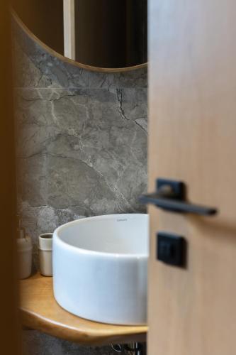 a white bowl on a wooden shelf in a bathroom at Kave luxurystaying in Volos