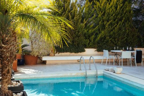 basen ze stołem i palmą w obiekcie 1BD Serene Calm Pool House w Atenach