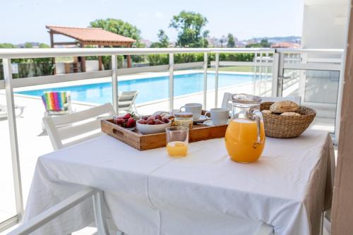 a table with a tray of fruit and orange juice at Carmona A T2 - By Smarthomes in São Martinho do Porto