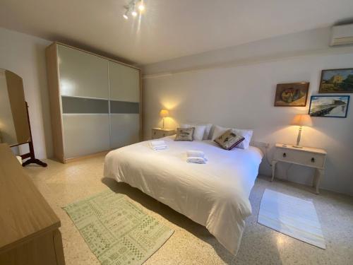 Tal-GħoqodにあるSt Julians Property with Terraceの大きな白いベッドと2つのランプがある寝室