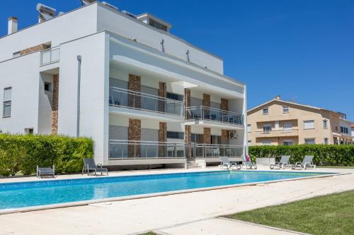 a villa with a swimming pool and a building at Carmona A T2 - By Smarthomes in São Martinho do Porto