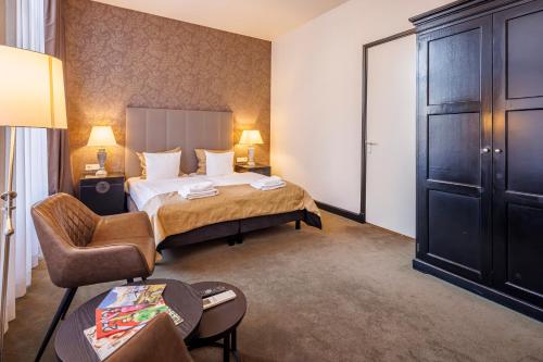 a hotel room with a bed and a chair at Grand Hotel Alkmaar in Alkmaar