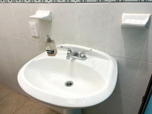 a white sink in a white tiled bathroom at Casa Elim-Oaxaca in Teotitlán del Valle