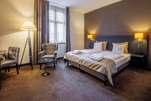 a hotel room with a bed and a chair at Grand Hotel Alkmaar in Alkmaar
