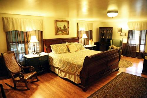 a bedroom with a bed and a chair in a room at Grandview Lodge in Waynesville