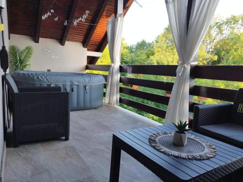 a patio with a hot tub and a table and chairs at Deluxe Apartment with Jacuzzi - PATAR in Rakovica