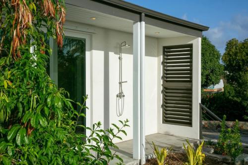 a small white house with a black shutter on it at Tropical Panorama in Cruz Bay
