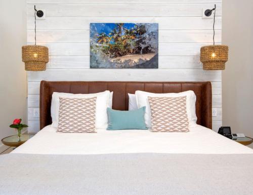 a bedroom with a bed with white sheets and pillows at Tropical Panorama in Cruz Bay