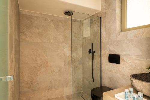 a shower with a glass door in a bathroom at Philosophy of Mykonos Boutique Hotel in Mýkonos City
