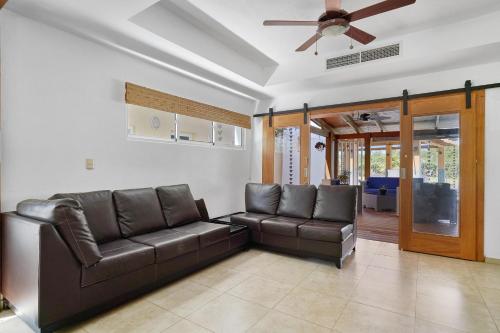 a living room with a couch and a ceiling fan at Comfy Spacious Villa W- Pool, Jacuzzi, Bbq in Juan Dolio