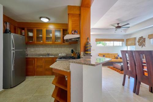 a kitchen with wooden cabinets and a stainless steel refrigerator at Comfy Spacious Villa W- Pool, Jacuzzi, Bbq in Juan Dolio