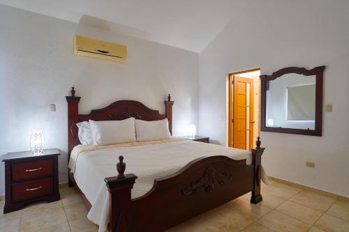 a bedroom with a large bed and a mirror at Comfy Spacious Villa W- Pool, Jacuzzi, Bbq in Juan Dolio