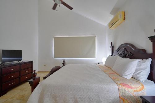 a bedroom with a bed and a flat screen tv at Comfy Spacious Villa W- Pool, Jacuzzi, Bbq in Juan Dolio